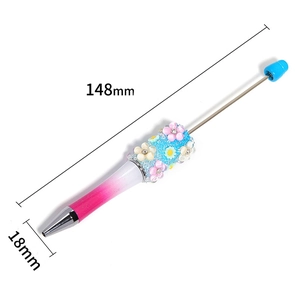Detail of DIY beadable pen showing blue 3D flower decor and pink gradient barrel