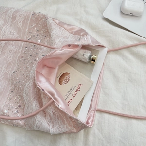 Detail of pink satin tote bag featuring delicate white lace overlays and sequin embroidery