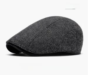 Close-up of dark gray wool newsboy hat showing detailed knit texture and classic brim