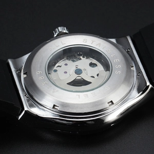 Macro detail of automatic mechanical watch with skeleton back and stainless steel case