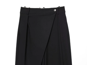 Detail of high-waisted black trousers with unique asymmetric wrap-front button closure