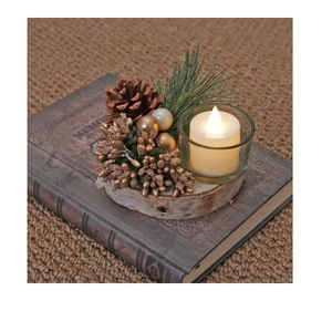Close-up of a Christmas candle holder with glass cup, pine cones and LED candle on wood