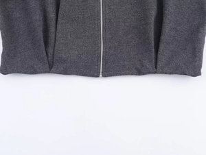 Detailed macro view of dark grey twill jacket hem with high-quality silver metal zipper