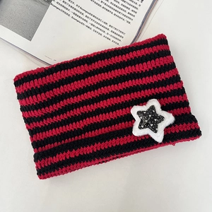 Detail of red and black striped knit hat featuring a plush star patch with a heart design