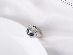 Detail eines Vintage-Silberrings mit blauen Katzenaugen und verstellbarem offenem Band
