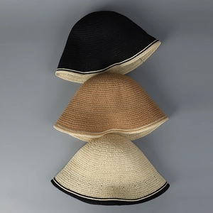 Detailed knit texture of crochet bucket hats in black, tan and beige with contrast trim