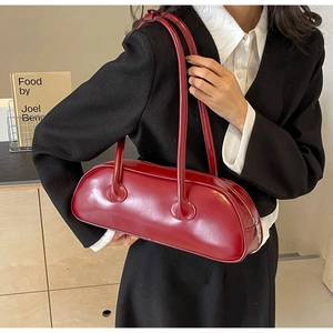 Chic red faux leather baguette shoulder bag shown on model with sleek double straps