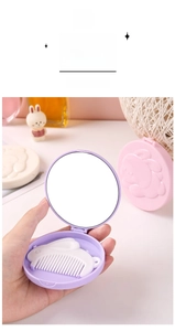 Detail of portable purple compact mirror with a cute white bunny-shaped hair comb inside