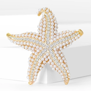 Elegant gold starfish brooch with white pearls and crystals on minimalist white background