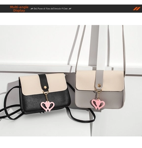 Detail of mini two-tone crossbody bags with flip-top cover and double heart leather charms