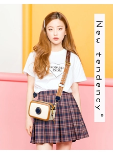 Detail of a color-block camera bag with a wide orange graphic strap and circular blue logo