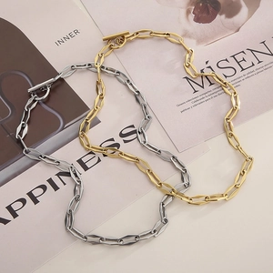 Detail of gold and silver rectangle link necklaces with OT buckle on a fashion magazine