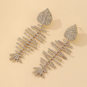 Détail macro de boucles d'oreilles squelette de poisson en strass avec sommet goutte d'eau