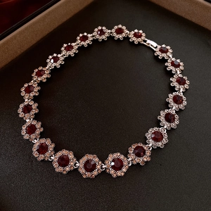 Exquisite flower bracelet with red gems and orange crystals in a luxury jewelry box