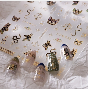 Macro detail of 3D embossed gold Ancient Egyptian nail art stickers with Horus Eye and Anubis