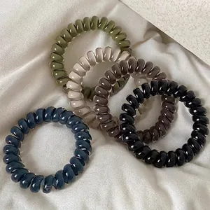 Five-color elastic spiral hair ties set with glossy resin finish on silk background
