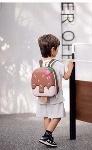 Close-up of children's 3D ice cream hard shell backpack with strawberry charm and straps