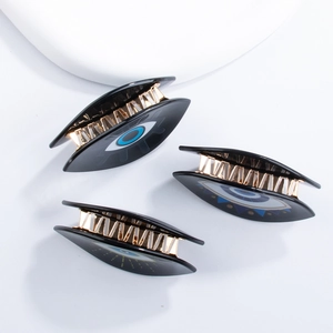 Black evil eye hair claw clips with blue eye pattern and gold-tone metal teeth