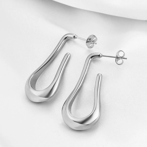 Polished silver 40mm teardrop hollow earrings in 304 stainless steel on white silk