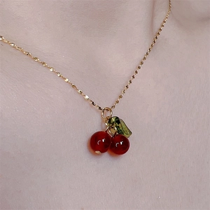 Minimalist gold chain necklace with red cherry pendant and green leaf detail for women