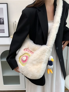 Cream plush crossbody bag with sweet donut embroidery and cute duck charm on model