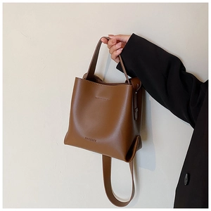 Close-up of the MACGKEE embossed logo on a vintage brown leather bucket bag for women