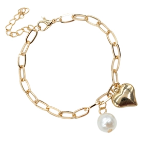 Detailed view of golden chain bracelet with heart charm and white pearl pendant close-up