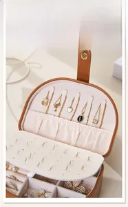 Detail of portable brown leather jewelry box with five necklace hooks and velvet lining