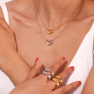 Detailed shot of gold and silver heart necklaces with irregular geometric metal rings