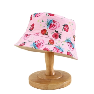 Pink strawberry pattern kids sun hat with wooden stand on a white background
