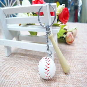 Miniature wooden baseball bat and white ball keychain hung on a decorative mini bench