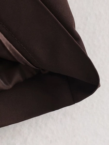 Detailed macro view of the dark brown twill fabric and double-stitched hem on the jacket