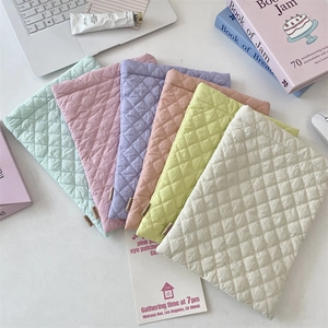 Detailed view of colorful quilted diamond pattern padded tablet and laptop sleeves