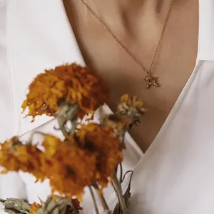 Minimalist 18K gold plated titanium balloon dog pendant necklace on a female model