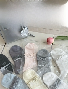 Detail of colorful cotton socks with delicate knitted lace trim in various pastel colors