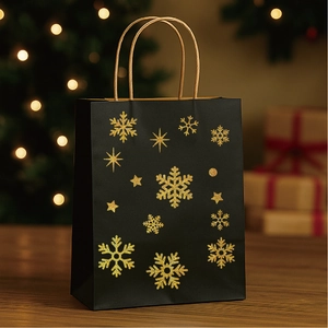 Christmas gift bag with gold glitter snowflakes and stars on a festive wooden surface