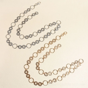 Detailed close-up of gold and silver circle disc chain belts with lobster clasp closures