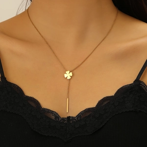 Macro view of 18k gold plated stainless steel clover necklace with tassel on model