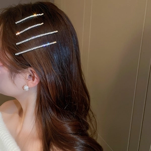 Close-up of sparkling rhinestone hair clips set worn on long brown wavy hair