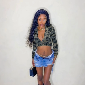 Short camouflage cropped zip jacket with distressed denim skirt and gold accessories