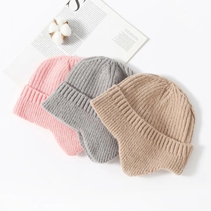 Detailed view of knitted ear protection beanies in pink, gray, and khaki colors