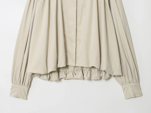 Detail des beige Rollkragenoberteils mit elastischem Faltenlagensaum und Bündchen