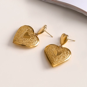 Detailed view of vintage gold heart-shaped locket earrings with engraved textures