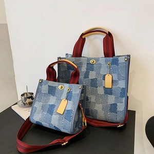 Detail of contrast color denim tote bags in two sizes with red striped handles
