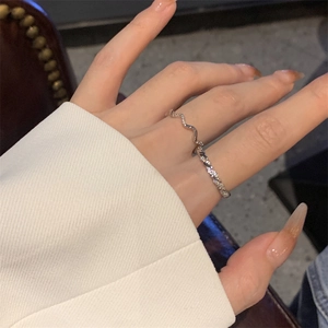 Stackable silver twist ring set with wave design and cubic zirconia on model hand