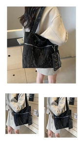 Detail view of black tote bag with crinkled leather texture and matching mini pouch