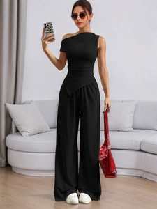 Modern black one-shoulder jumpsuit with wide legs and waist-tie in a minimalist style