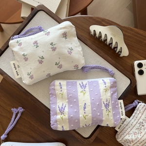 Close-up of lavender floral cotton mini pouch with texture and brand label