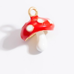 Vue détaillée d'un pendentif champignon rouge et blanc avec boucle dorée pour bijoux