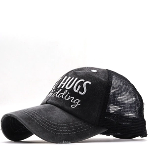 Detail of HUGS kidding embroidery on washed cotton distressed ponytail baseball cap